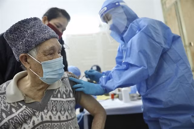 An elderly man in Hàng Bông Commune, Hà Nội, receives a COVID-19 vaccine. The city is ramping up its vaccination drive to ensure people in high-risk groups are fully vaccinated.