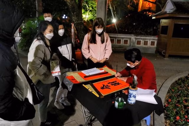 People wait for their traditional Tết calligraphy paintings at Ngọc Sơn Temple, Hà Nội. VNA/VNS photo Tuấn Đức
