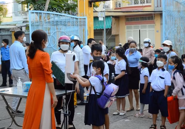 Kindergarten children and students from first to fourth grades take COVID precautions in the southern province of Đồng Tháp as they returned to school on Monday.