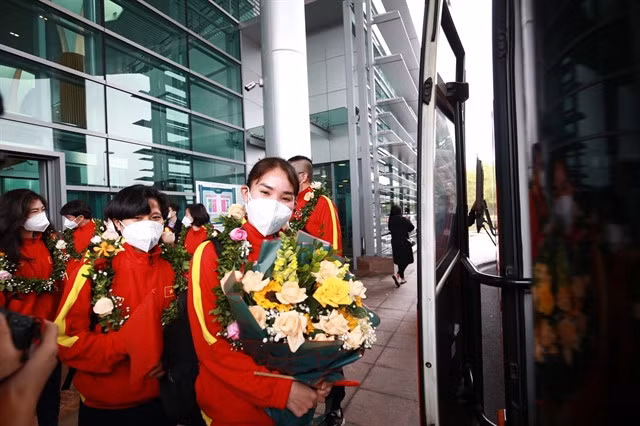 Defender Chương Thị Kiều is happy to be home with welcome flowers from the Việt Nam Football Federation.