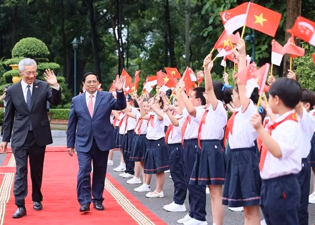 Hà Nội children welcome Prime Minister Phạm Minh Chính and Singapore Prime Minister Lee Hsien Loong on Monday. — VNA/VNS Photos