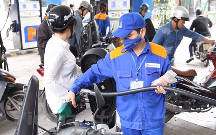 A motorcyclist has her vehicle refilled at a petrol station in Hanoi.