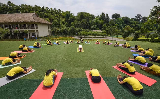 Visitors join an outdoor yoga class as part of their tour to An Lac Eco Farm &amp; Hot Springs in Hoa Binh province. (Photo: VnExpress)