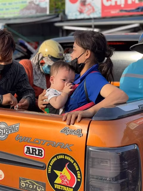 A mother and child are transported by a club member's pickup truck.