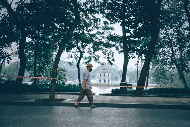 A man walks alone Đinh Tiên Hoàng Street by Hoàn Kiếm Lake.