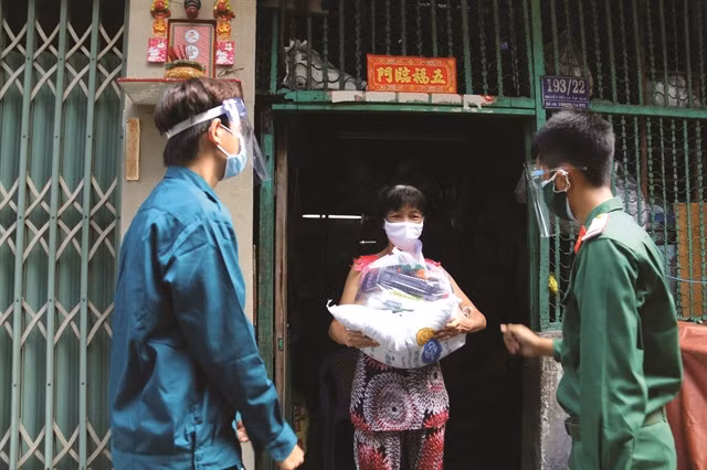 Soldiers giving goods to a resident in an alley on Nguyễn Tiểu La Street, HCM City's District 10. — VNA/VNS Photo Thanh Vũ