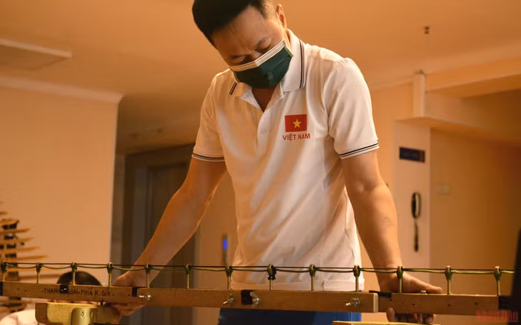 Dr. People’s Artist Nguyen Xuan Bac prepares to assemble a lithophone.