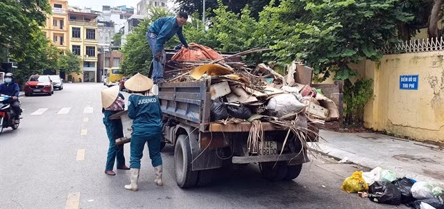 Environmental sanitation workers collect garbage along a road in Hạ Long City, Quảng Ninh Province.