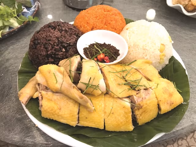 TRICOLOR: A beautiful combination of boiled Tiên Yên chicken with assorted sticky rice with black beans, red sweet gourd and lotus seed and coconut shreds.