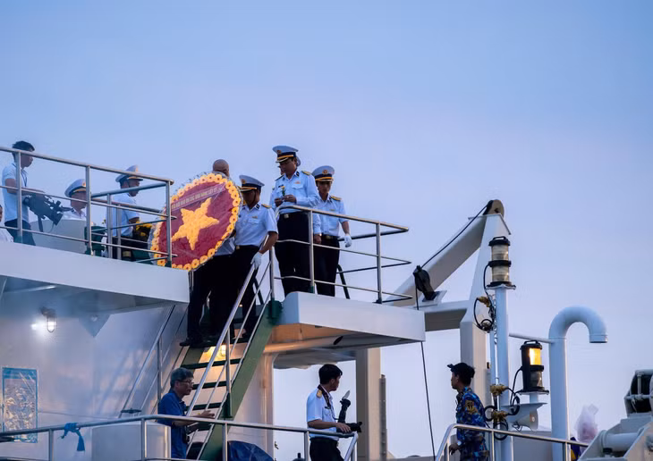 The wreath is carried down to the area for release into the sea.