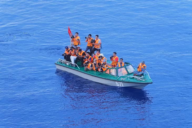 Reporters leave the main ship and board a small canoe to capture the memorial service from afar.