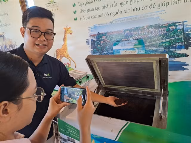 An engineer from Autotech Machinery company (left) introduces a kitchen waste treatment system -- Waste2Green -- in Hội An. The system could process 30kg of organic waste into nutrient compost for organic farming. — VNS Photo Công Thành