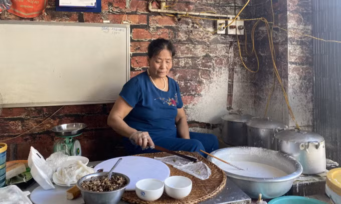 Hoang Thi Lan makes rice rolls at the entrance of her eatery in Thanh Tri Village, Hanoi. Photo by VnExpress