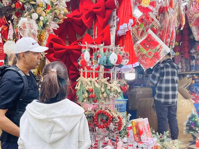 Foreign tourists view Christmas decorations on Hàng Mã Street, Hà Nội. — VNA/VNS Photo