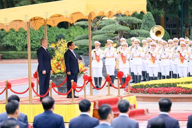 Prime Minister Phạm Minh Chính and Chairman of the Cabinet of Ministers of the Kyrgyz Republic Adylbek Aleshovich Kasymaliev listen to the national anthems of the two countries. — VNA/VNS Photo Dương Giang