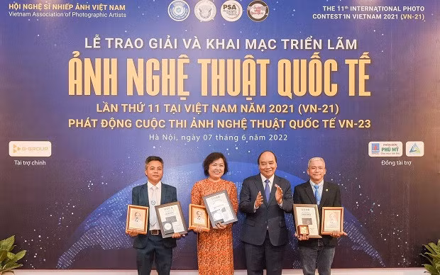 President Nguyen Xuan Phuc awards gold medals and certificates to photographers who won the highest prizes of the contest. (Photo: VAPA)