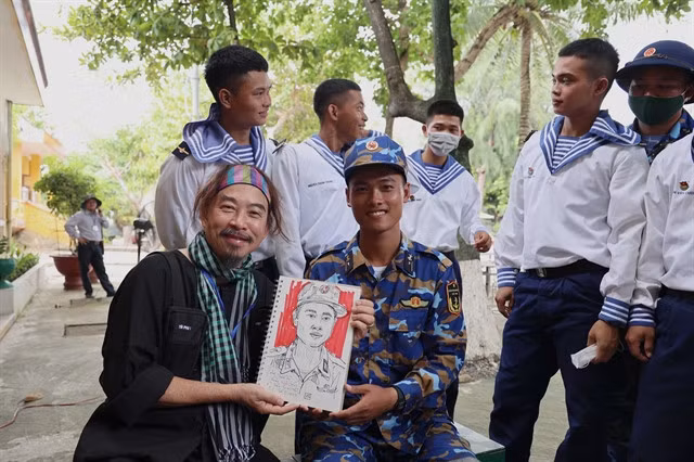Etcetera Nguyễn, also known as Nguyễn Quang Trường, presents a portrait to a soldier on the Trường Sa (Spratly) islands.