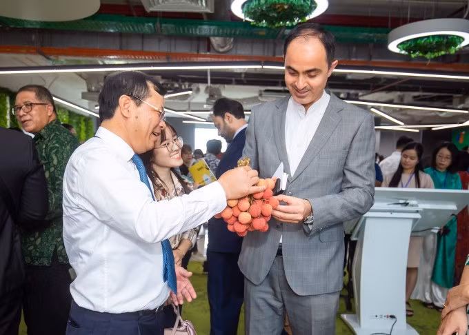 A foreign delegate visits the Vietnamese lychee exhibition booths. Photo by Tung Dinh