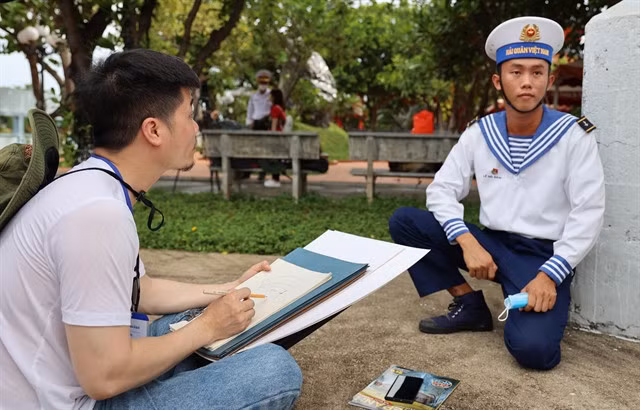 Nguyễn Văn Trinh, an overseas Vietnamese, draws a soldier’s portrait on the island.