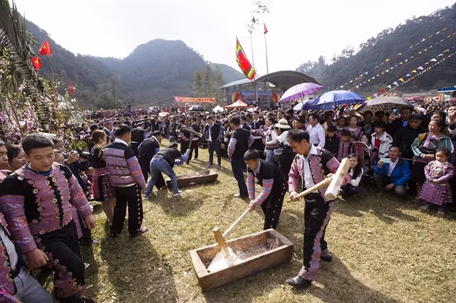 Festival-goers join the competition of pounding sticky rice cakes, a specialty dish of the Mông people during festive occasions.