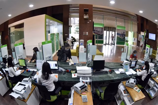 Clients come for transactions at an office of Vietcombank in Hà Nội. Shares of the lender surged nearly 4 per cent on Tuesday, leading the market's bullish trend. — VNA/VNS Photo
