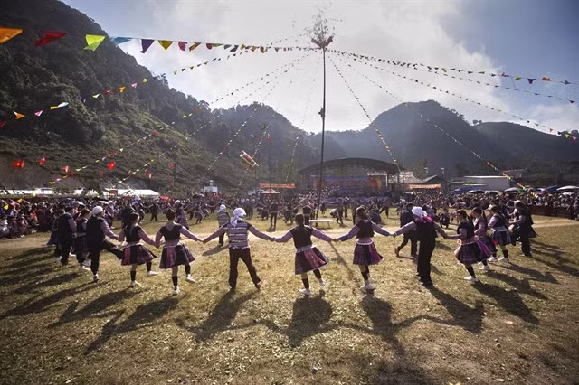 Mông people dance around a bamboo pole, a sacred symbol of repelling bad luck and bringing good luck for the New Year.