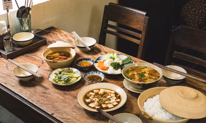 A meal for four people includes tofu, egg-tomato soup, steamed veggies, braised pork, and pickles. Photo by VnExpress/Tung Le