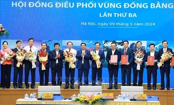 Prime Minister Pham Minh Chinh (middle) hands over to leaders of localities the decisions approving planning of cities and provinces in the Red River Delta region (Photo: VNA)
