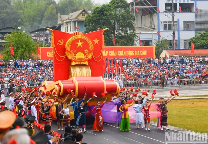 A float carrying the National Emblem of the Socialist Republic of Vietnam.