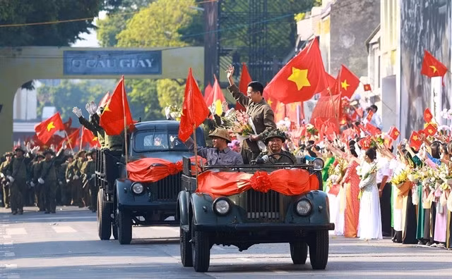 The re-enactment of the army marching in to take over the capital amid a sea of flags, flowers, and the joy of victory. — VNA/VNS Photo Dương Giang