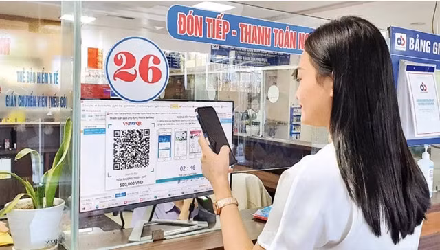 A woman pays for medical examination via QR code at a hospital in Hà Nội. — Photo nhandan.vn