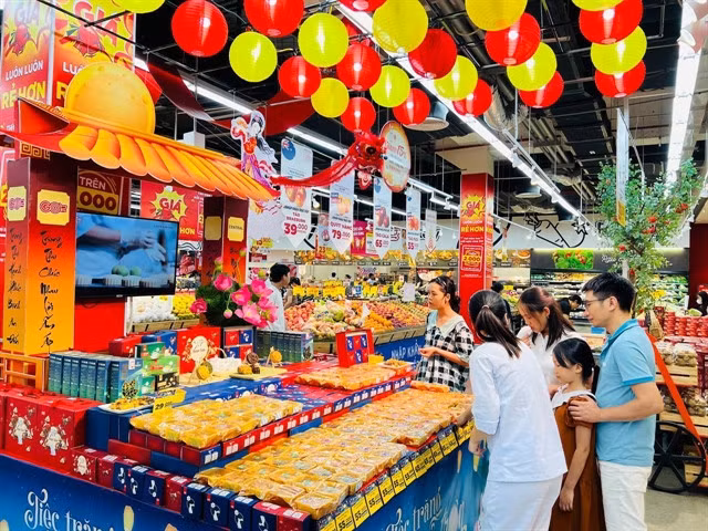 Customers buy mooncakes at a supermarket in HCM City. Mooncake producers have launched many new products for the Mid-Autumn Festival this year. — Photo courtesy of Central Retail