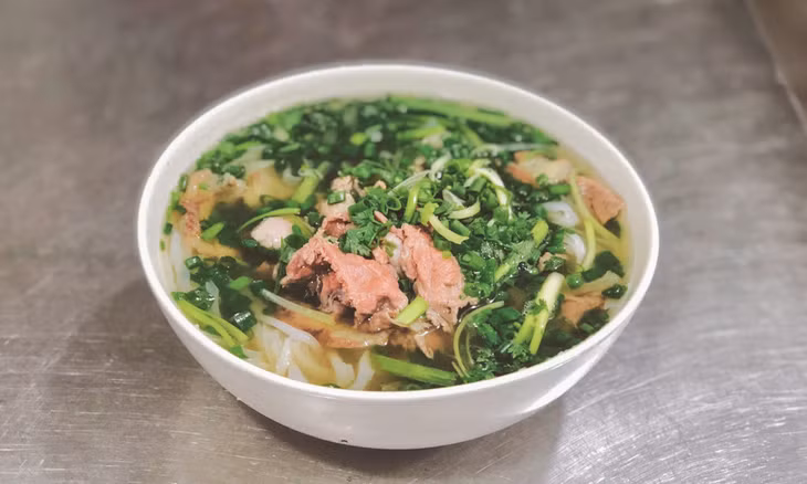 A bowl of Hanoi-style pho is topped with lots of scallions. Photo by VnExpress/Quynh Mai