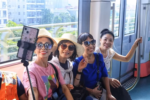 Passengers record the moment of their first time riding the elevated train on Thursday morning.—VNA/VNS Photo Tuấn Anh