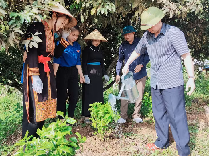 Lãnh đạo huyện, cán bộ Đảng viên và nhân dân thôn Đồng Doong, xã Minh Cầm trồng và chăm sóc hoa. Ảnh: Phạm Học