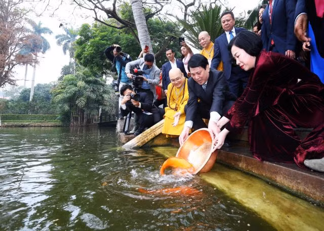 State President Lương Cường and his wife on Sunday joined overseas Vietnamese in a traditional ritual releasing carp for “Ông Công, Ông Táo” (Land Genie and Kitchen Gods) at Uncle Hồ’s fish pond in the Presidential Palace Relic Site. VNA/VNS Photo
