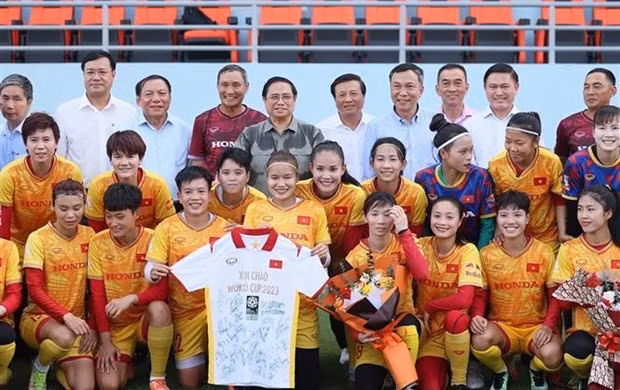 Prime Minister Phạm Minh Chính (3rd row, fifth from left) in a group photo with the women's national football squad in Hà Nội on July 3. VNA photo