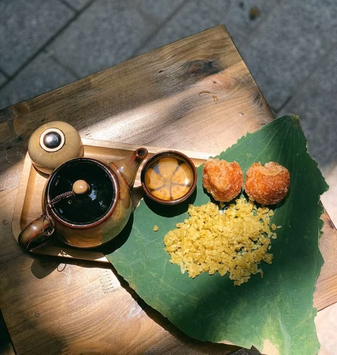 Young green rice is placed on a piece of lotus leave, together with fried rice cakes and tea at a shop in Hanoi. Photo by VnExpress/Thao Nhi