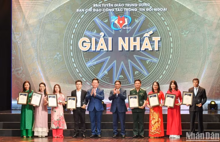 Prime Minister Pham Minh Chinh and Head of the Central Commission for Communication and Education present the first prizes to the winning authors.