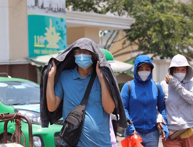 Local residents in Hà Nội wear face masks. VNA/VNS Photo