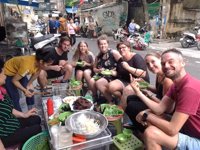 A group of foreign tourists enjoy street food in Hà Nội. Photo vietnamopentour.com.vn