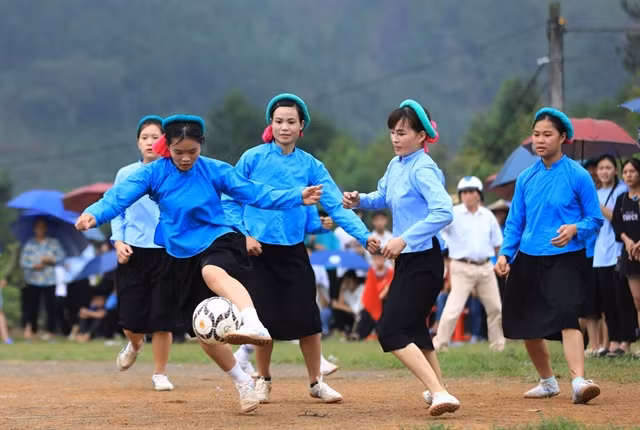 Sán Chay women playing football while wearing their traditional costumes.