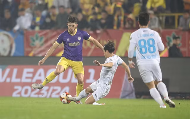 National striker Nguyễn Văn Toàn of Nam Định (centre) makes a tackles the match between Nam Định and Hà Nội on February 28. Photos of VPF