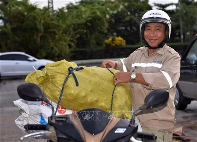 A worker at the factory happily delivering the trash collected by the factory. — VNA/VNS Photo