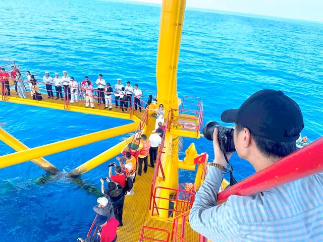 A journalist takes photos on the platform during the visit to Trường Sa (Spratly) Archipelago. VNA/VNS Photo Thùy Giang