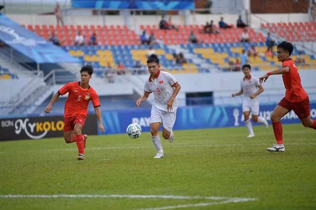 Đinh Xuân Tiến of Việt Nam (centre) runs past Lao players during their AFF U23 Championship on August 20 in Rayong, Thailand. Việt Nam won 4-1. VNA/VNS Photo