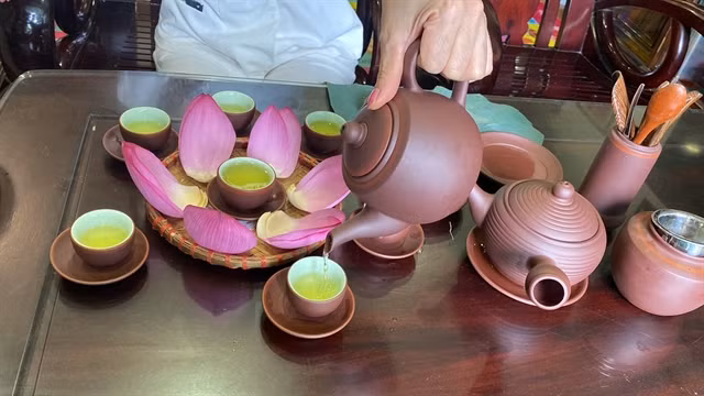Thủy pours lotus tea into a traditional tea set. VNS Photo Lê Hương