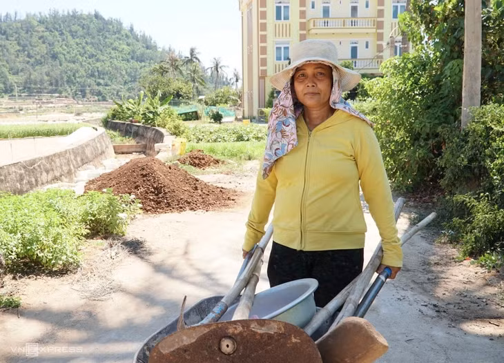 Tran Thi Cuong, a hotel owner in Ly Son Island, pushes a wheelbarrow back from her onion farm. Photo by Chau Dai Duong